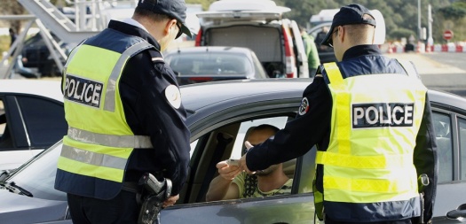 French police officers control the driver of a car on the A9 motorway at Le Perthus near the French-Spanish border on November 13, 2015. 30,000 police officers, including 4 000 border police (PAF : Police aux frontières), are mobilized from November 13 until December 13 to help secure French borders at 285 crossing points as part of the COP21 environmental summit to be held in Paris. Thousands of customs officers will also take position regularly on former checkpoints. AFP PHOTO / RAYMOND ROIG / AFP / RAYMOND ROIG